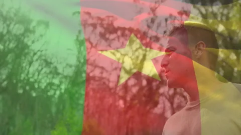 Starting tutorial showing man standing in woods with Cameroon-flag and rotating 스톡 동영상 310428802