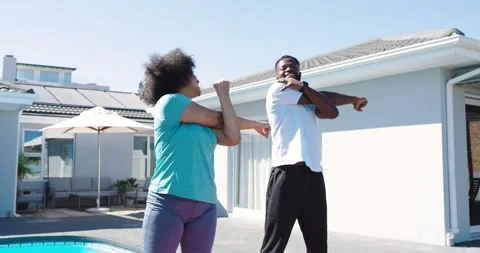 Starting warmup, Diverse friends moving through stretches at backyard pool Stock Footage 335807941