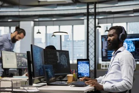 Startup admin integrating AI machine learning systems in office, listening music Foto stock