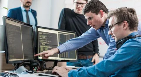 Startup business problem solving. Software developers working on desktop Stock Photos