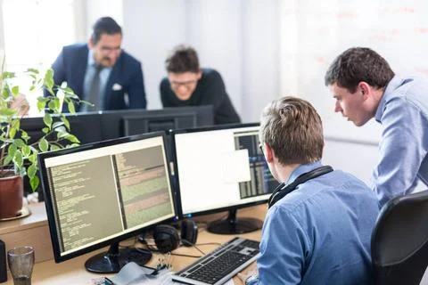 Startup business problem solving. Software developers working on desktop c... Foto stock