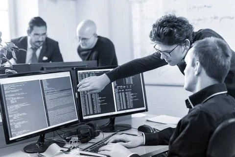 Startup business problem solving. Software developers working on desktop c... Stock-Fotos