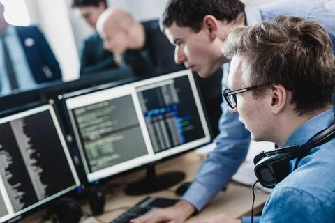 Startup business problem solving. Software developers working on desktop c... Stock-Fotos