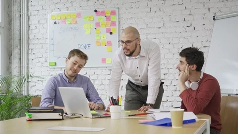 Startup concept. Group of three young man discussing Stock Footage 94576363