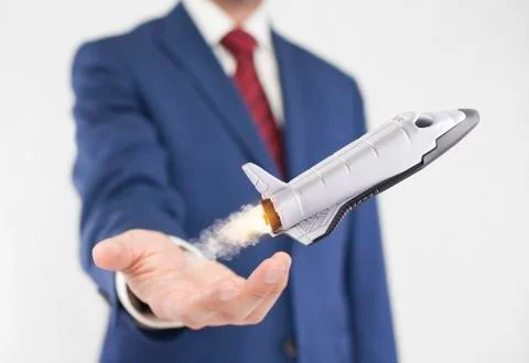 Startup concept. Space shuttle takes off from the hand of the businessman Stock Photos
