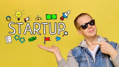 Startup concept - young guy smiling on yellow background. Stock Photos