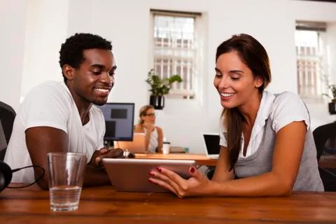 Startup entrepreneurs discussing a tablet computer Stock Photos