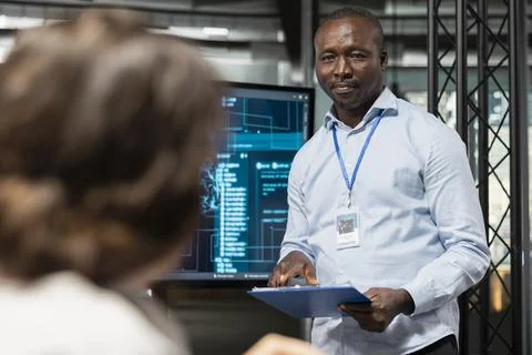 Startup manager discussing AI tech roadmap with workers during briefing Stock Photos