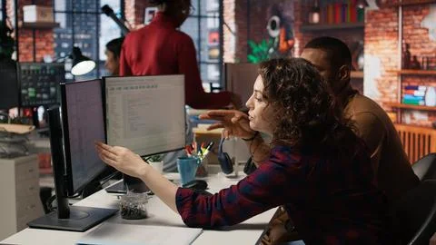 Startup programmer collaborating with colleague to test company software Foto stock