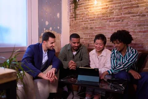 Startup team analyzing data on tablet in cozy office space Stock Photos