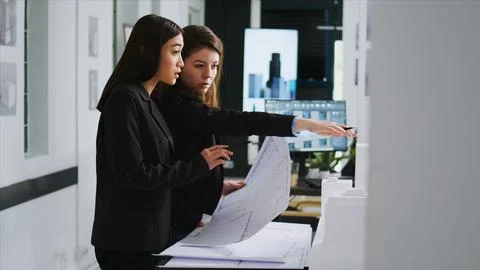 Startup team working with architectural blueprint plans Stock Photos