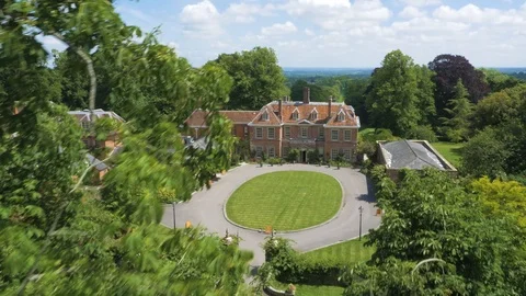Stately home revealed through trees with landscaped gardens, drone aerial 4K Stock Footage 101136255