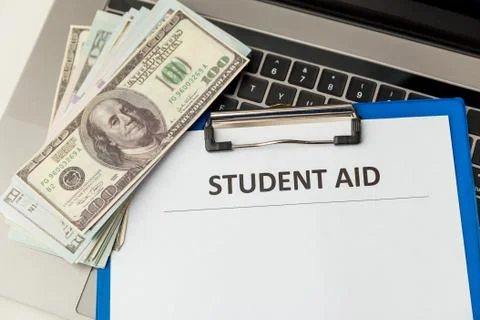 Statement form of student aid and money on the table. Stock Photos