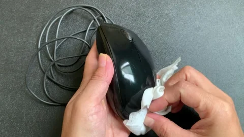 Static 4K shot of hands cleaning computer mouse with wet wipe Stock Footage 347992480
