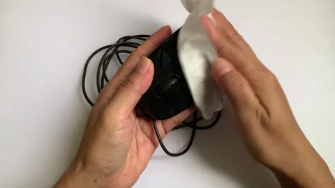 Static 4K shot of hands cleaning computer mouse with wet wipe on white desk Stock Footage 347992482
