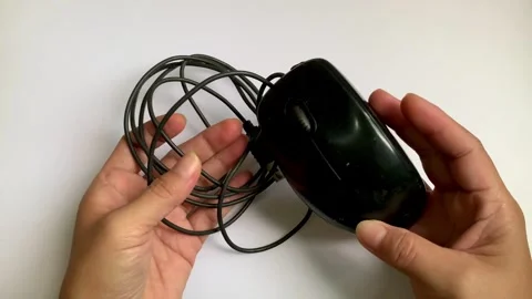 Static 4K shot of hands inspecting computer mouse on white desk Stock Footage 347992468