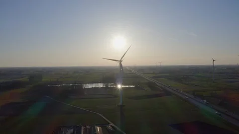 Static aerial drone shot of multiple windmills lined up with sun above Stock Footage 127054465