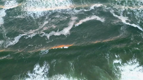 Static aerial looking down at ocean waves backlit by the sunset Stock Footage 249028991