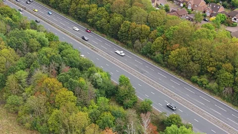 Static Aerial over Busy Road near Trees and Houses in Surrey, UK. Stock Footage 346593375