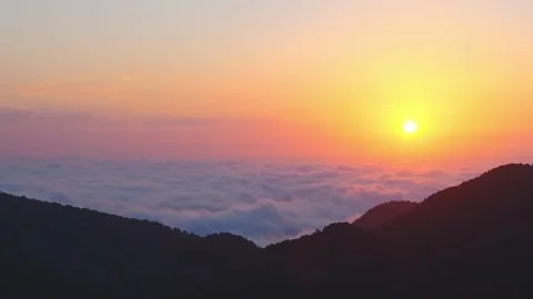 Static aerial panoramic view of sun rising above horizon with clouds above fo Stock Footage 204838061