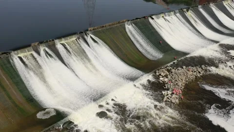 Static aerial shot of a dike dam with moderate overflow into a river - 4K Stock Footage 160909527