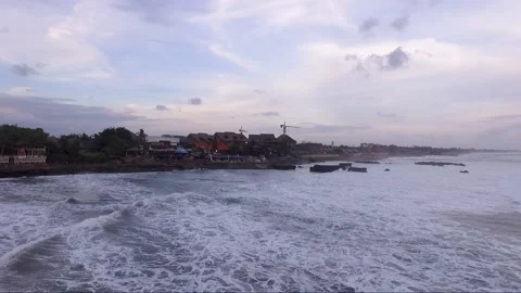 Static aerial shot of waves breaking on seawall with buildings nearby Stock-Footage 160808191