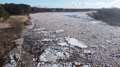 Static aerial view of a huge blocks of pack ice going down the river Gauja Stock Footage 149819222