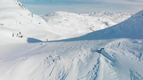 Static aerial view of person walking on snow ridge in mountain landscape Stock Footage 145889388