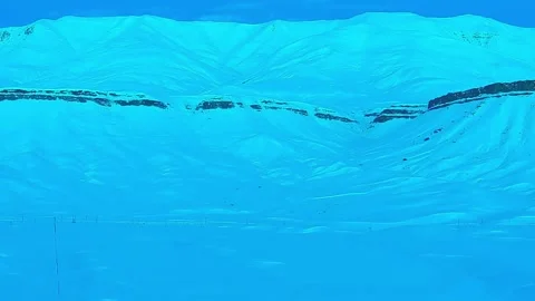 Static Aerial View of Snow-Covered Mountain Ridge with Rock Layers in Blue W Stock Footage 327765484