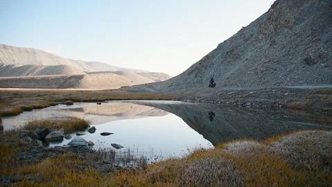 Static back view adventurous fit traveller cycle bicycle touring solo in re.. Stock Footage 281437250