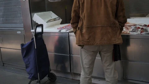 Static back view of a middle aged man at a fish stall at an indoor market. Stock Footage 122293575