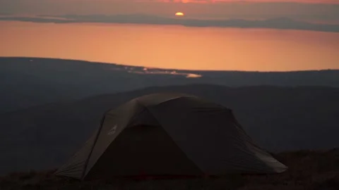 Static background shot of a tent high in the mountains at sunset Video stock 205236586