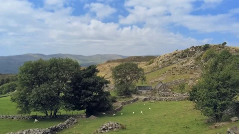 Static camera. Clouds move fast, old welsh stone building in mountains with t Stock-Footage 94257567