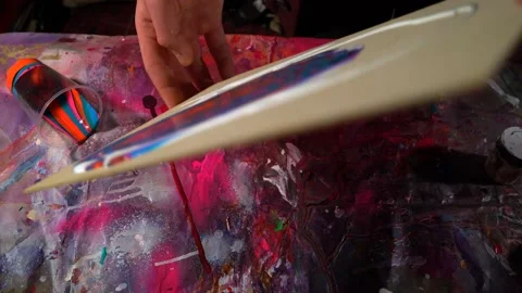 Static camera shot professional male painter tilting canvas with acrylic paints Stock Footage 154613974