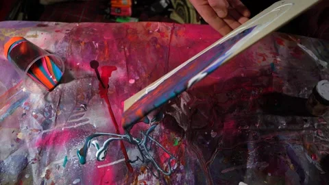 Static camera shot professional male painter tilting canvas with acrylic paints Stock Footage 154613997
