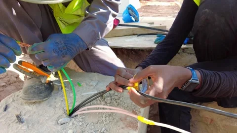 Static Close-Up of Electricians Collaborating on Electrical Cable Wiring 库存影片 345804594