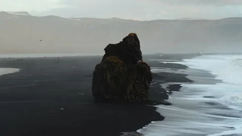 Static close-up of Reynisdrangar sea stack with seagulls and crashing waves.. Stock Footage 327683719