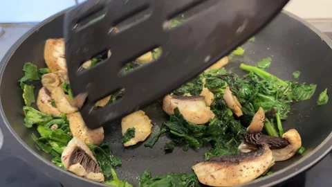 Static Close Up Sautéed Mushrooms and Spinach Stir Fry in Dark Pan Stock Footage 341229953