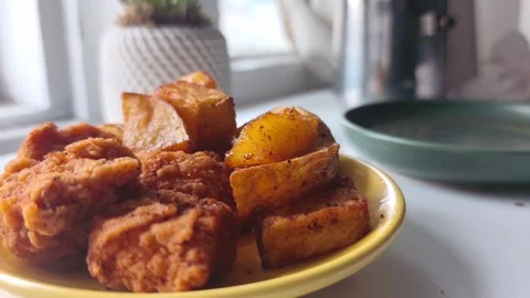 Static close-up shot of a bright yellow plate stacked with crispy fried chicken Vídeos de archivo 334785621