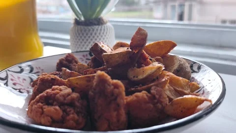 Static close-up shot of a hand picking up a seasoned crispy potato wedge from a Stock Footage 334700056