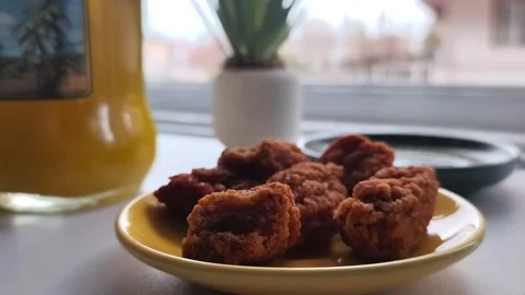 Static close-up shot of a plate filled with crispy fried chicken nuggets while a Vídeos de archivo 334785650