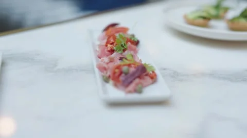 Static close-up shot of a refined appetizer served on a white rectangular Stock Footage 333675552