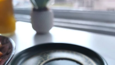 Static close-up showing a hand lifting a steaming green coffee cup from its Vídeos de archivo 334700082