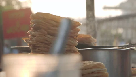 Static close up showing pile of burmese paratha baking outdoors early in 스톡 동영상 132959638