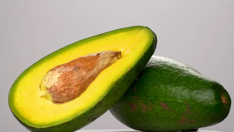 Static Close Up Whole And Half Avocado With Seed On White Background 4K Stock Footage 322088661