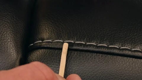 Static Closeup of Craftsman Repairing Scratch on Black Leather Furniture Stock Footage 308915401