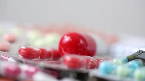 Static closeup shot of a big pill rotating on top of blisters Stock Footage 280677560
