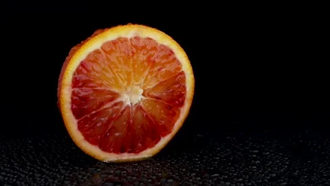Static Cut Red Sicilian Orange with Water Droplet on Peel and Wet Surface on Bla Stock Footage 312148525