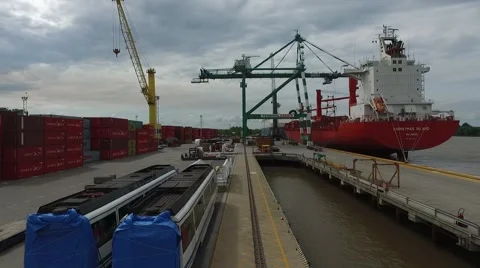 Static drone aerial riverside scene flying between containers a huge crane and a Vídeo Stock 59995420