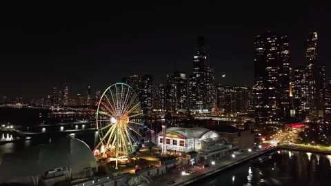 Static drone shot the illuminated Navy pier and the skyline, evening in Chicago Vídeos de archivo 302715194